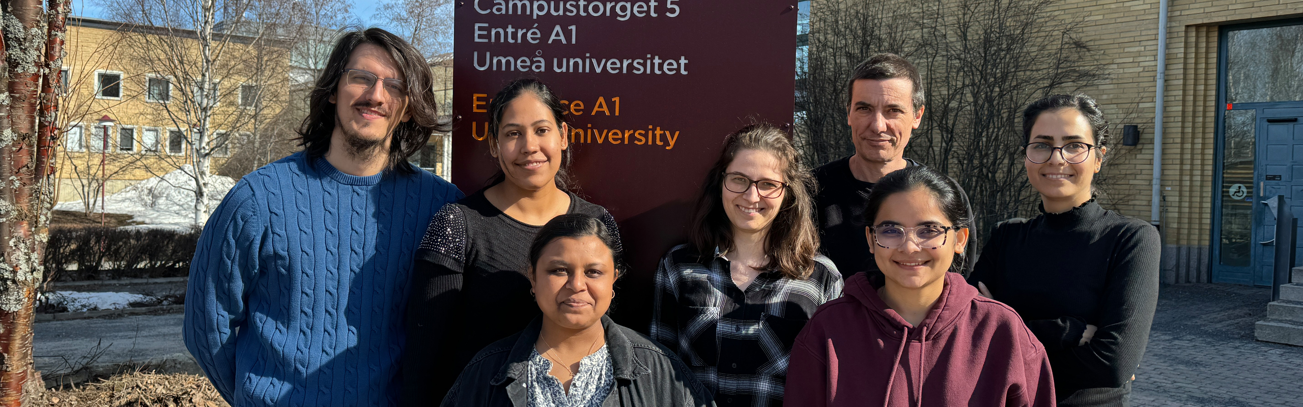 Forskargruppens medlemmar står på utsidan av MIT-huset i solen.