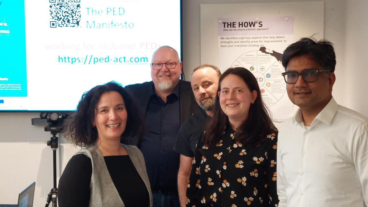 En grupp människor som står framför en projektorduk.