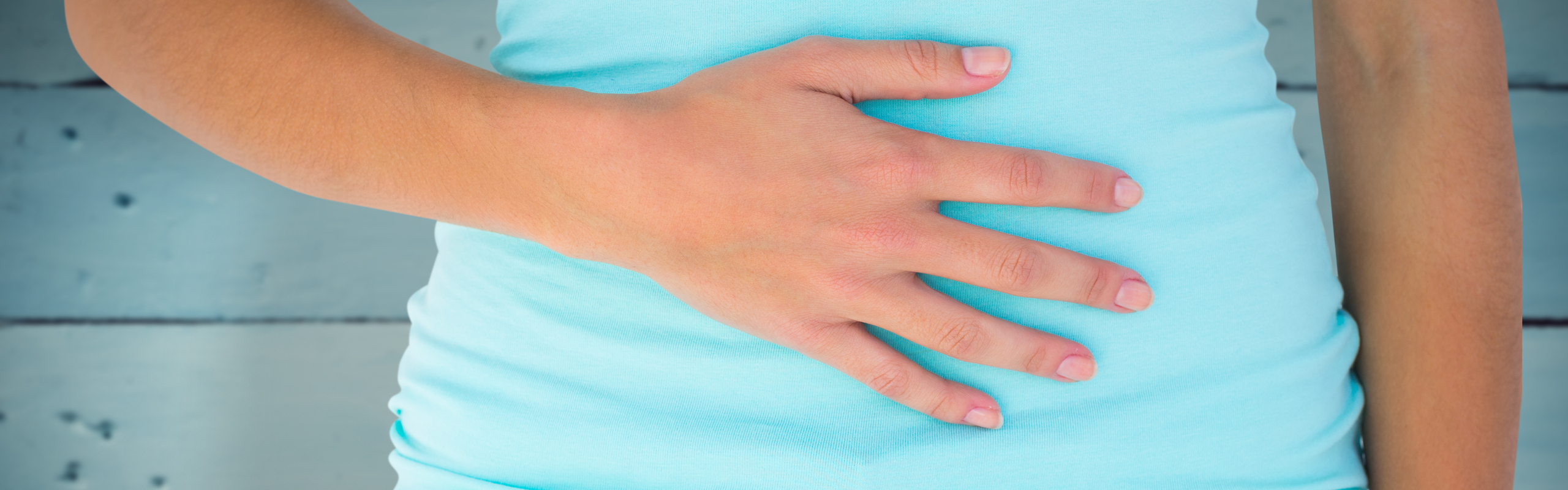 Detalj av kvinna som håller handen på magen.