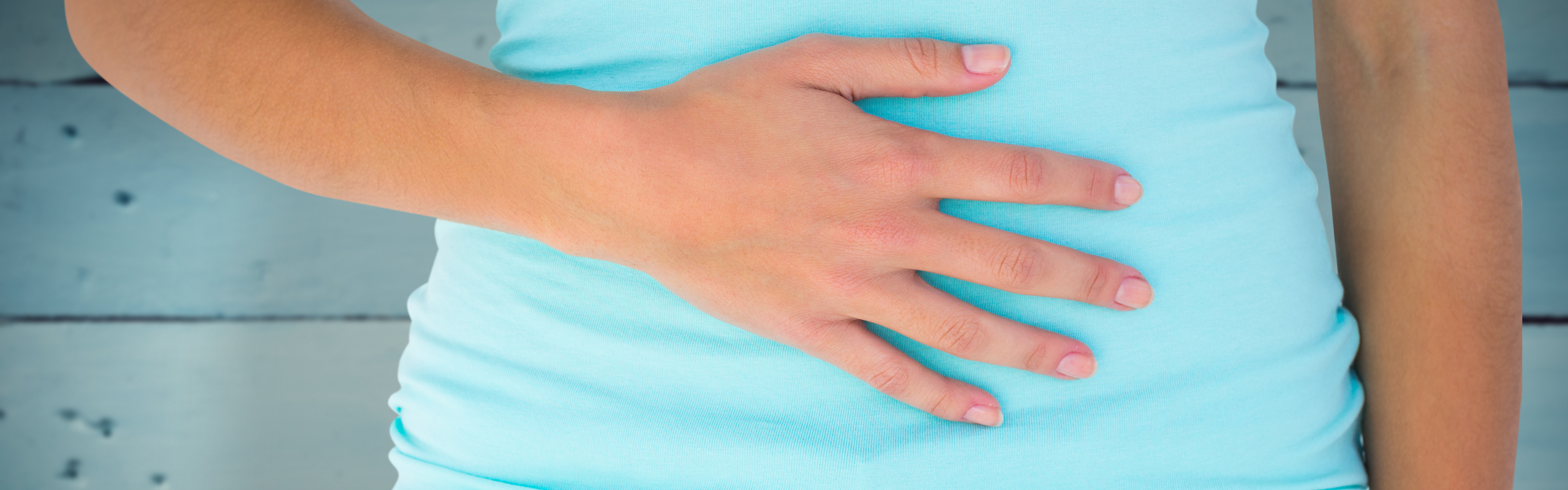 Detalj av kvinna som håller handen på magen.