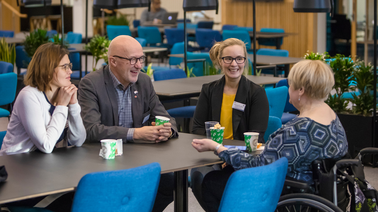 Deltagare i AIMday 2018 samtalar vid ett bord.