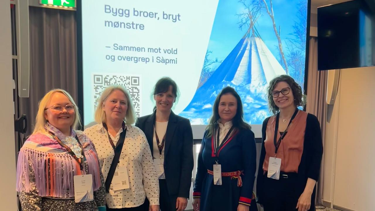 En grupp kvinnor står framför en projektorskärm.