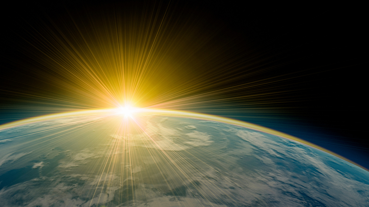 Del av jordklot med solen vid horisonten.