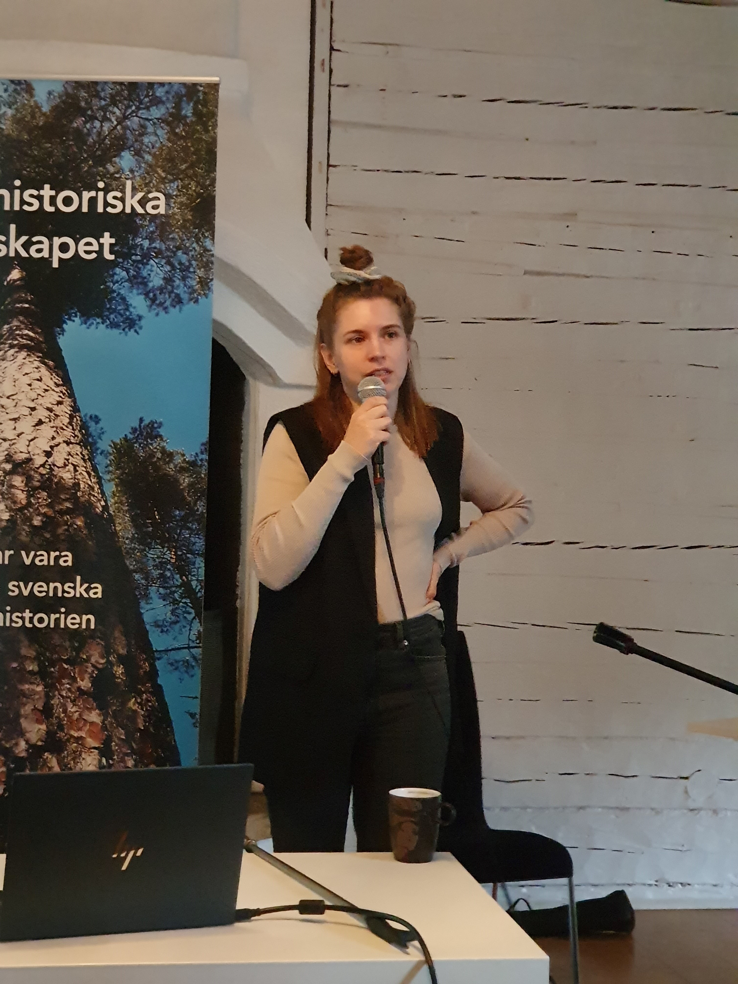 Irma Olofsson står och talar med en mikrofon i handen