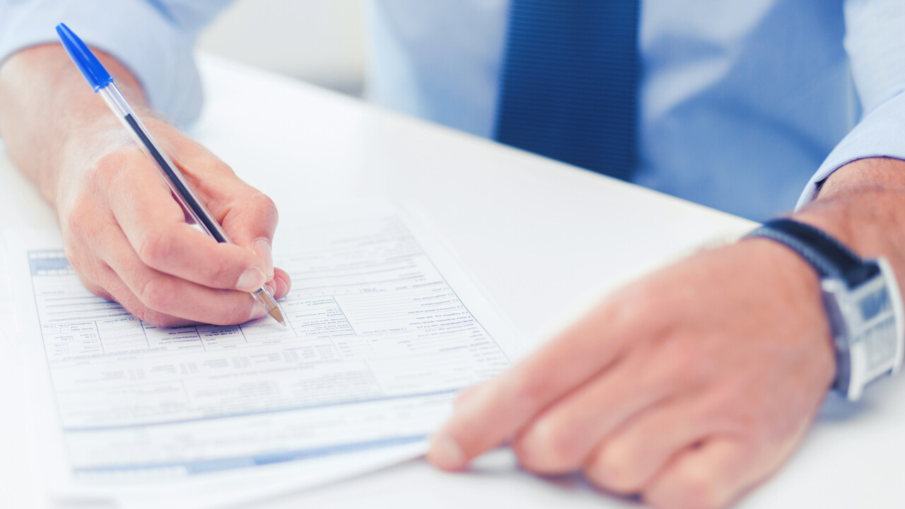 Ett par händer som skriver under ett dokument