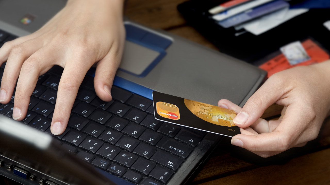 Närbild på person som gör en kortbetalning via internet.