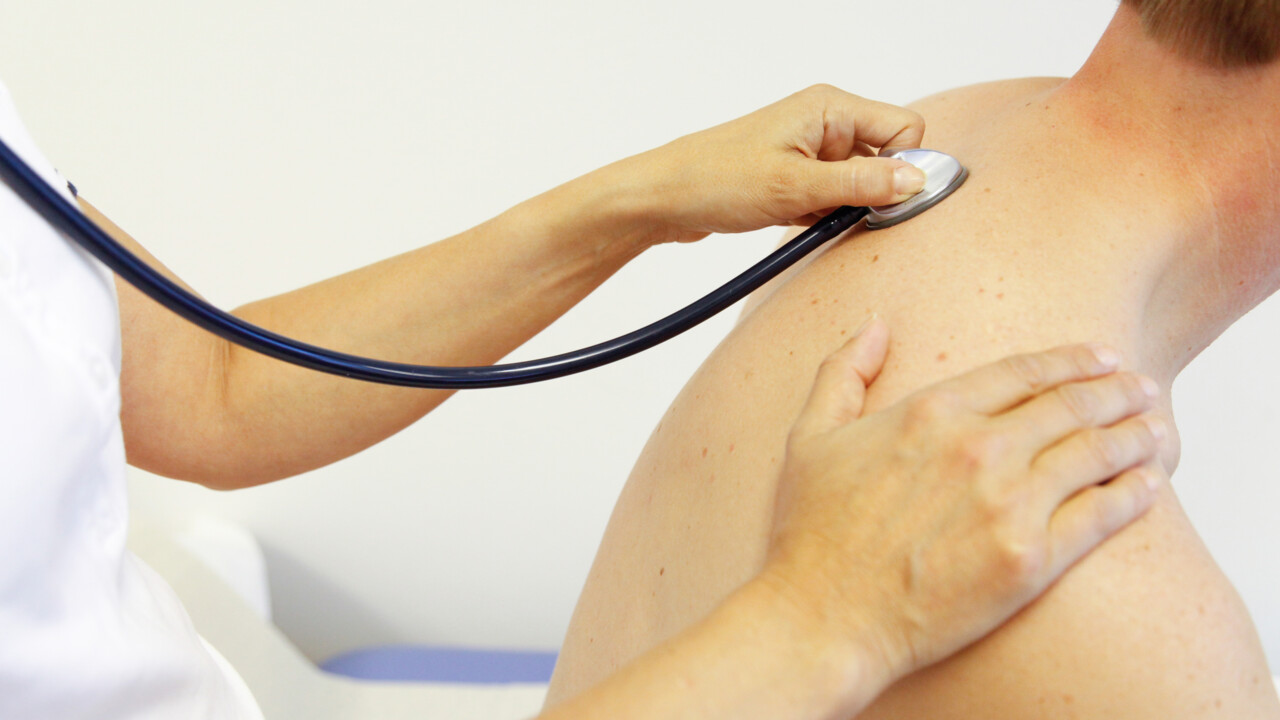  Läkare undersöker patient med stetoskop. 