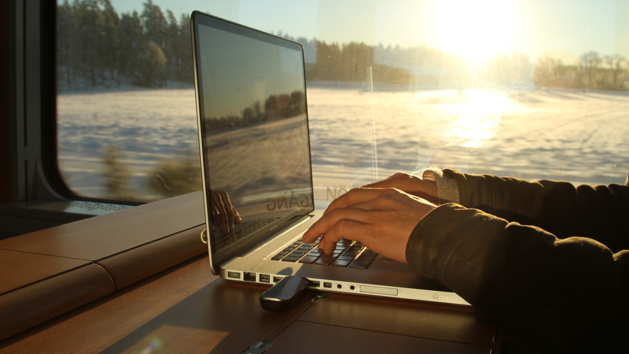 Bild på tågresenär som sitter vid sin dator
