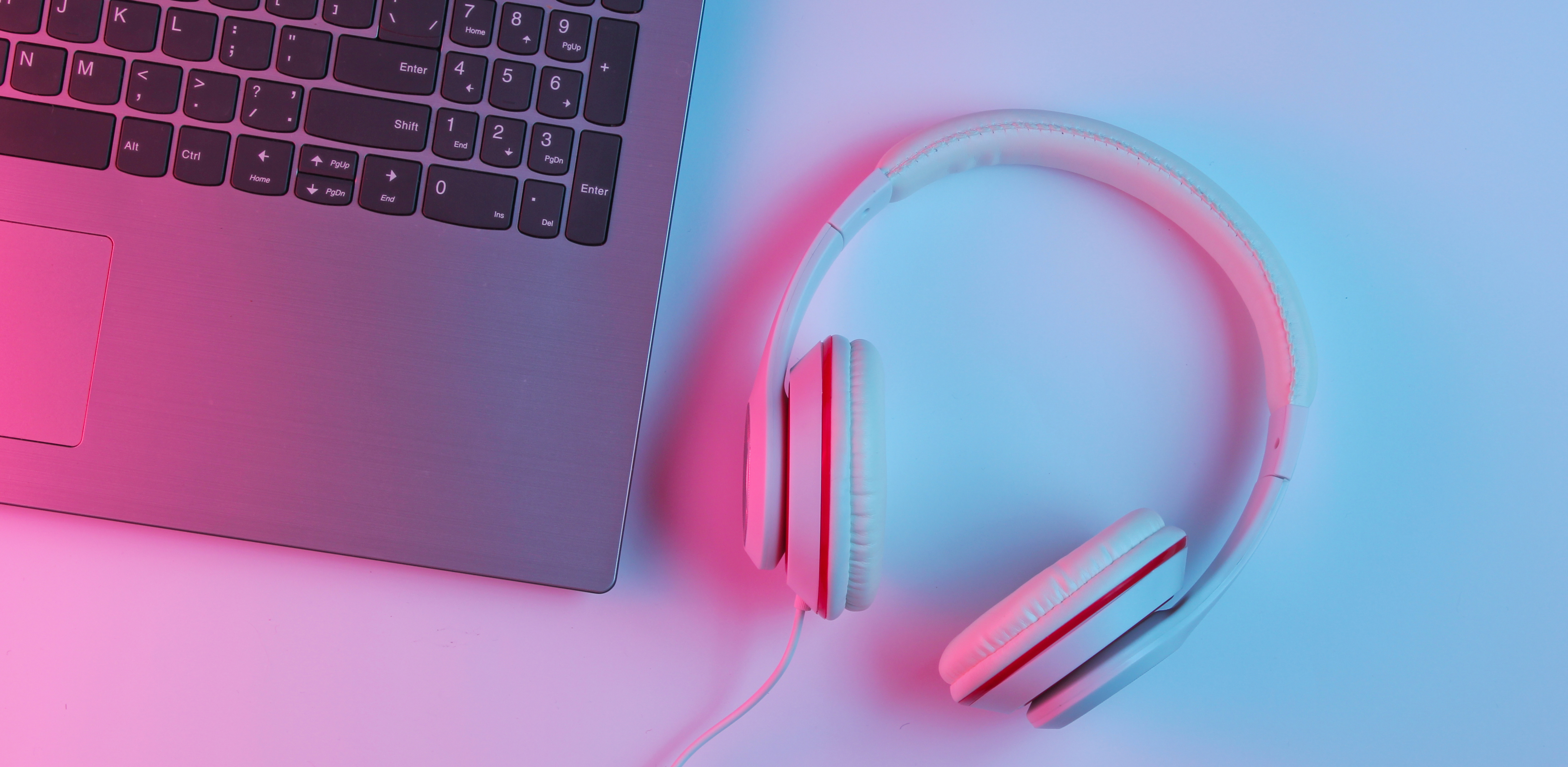 Detalj. Del av dator och headset på bord.