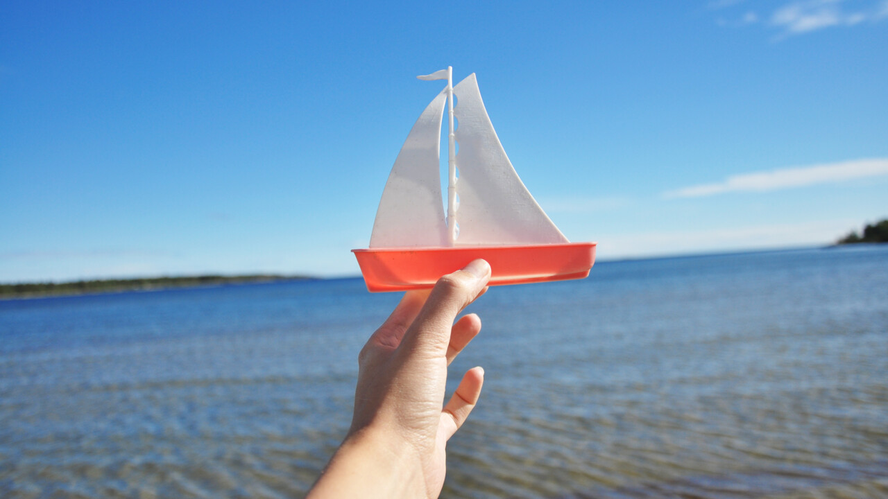 Leksaksbåt som hålls upp mot horisonten.