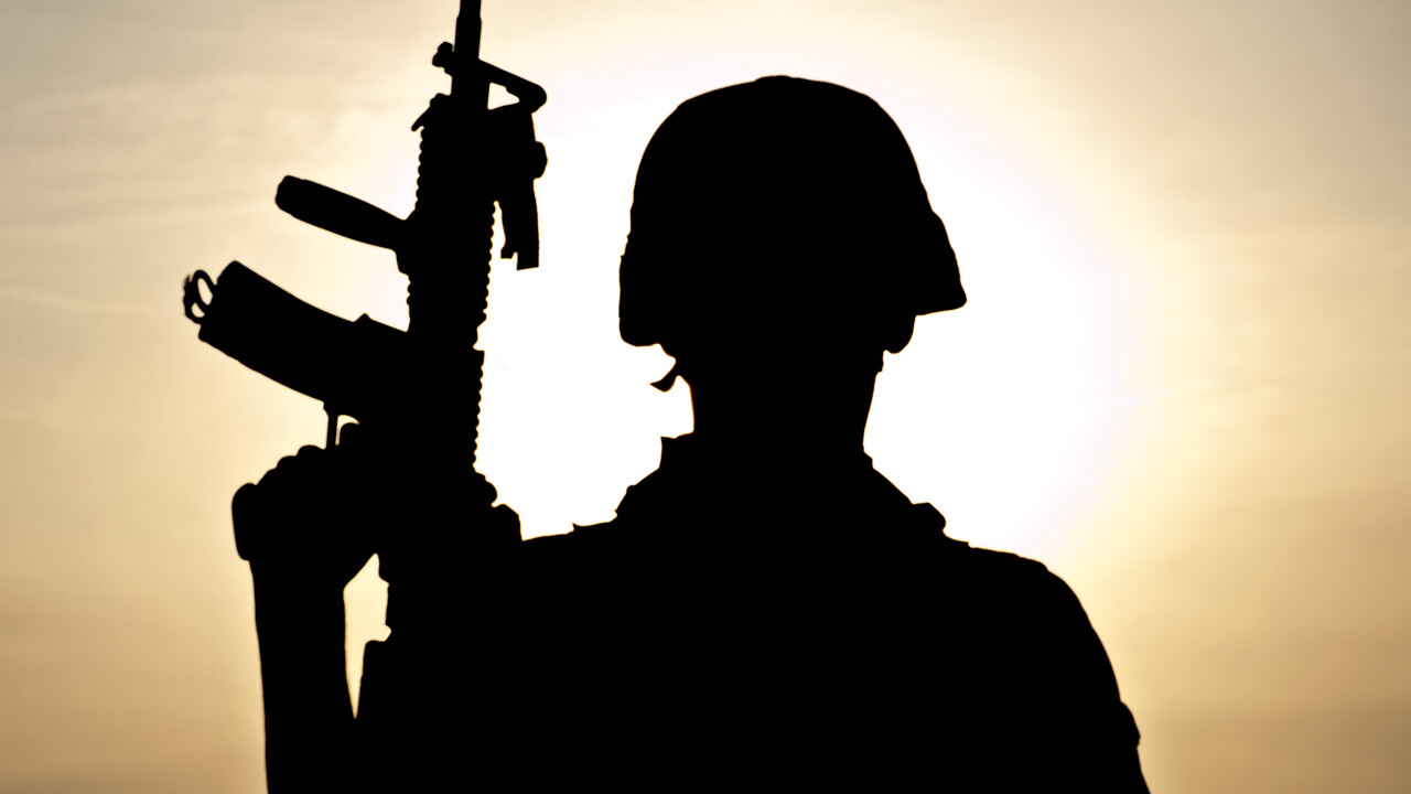 Militär med vapen i motljus