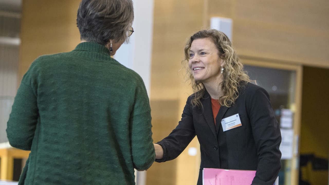 En av arrangörerna hälsar dagens deltagare välkomna.