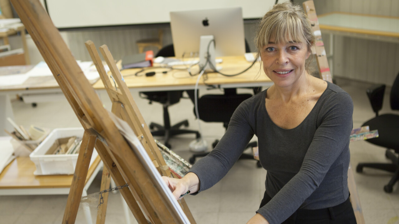 En kvinna står vid ett staffli