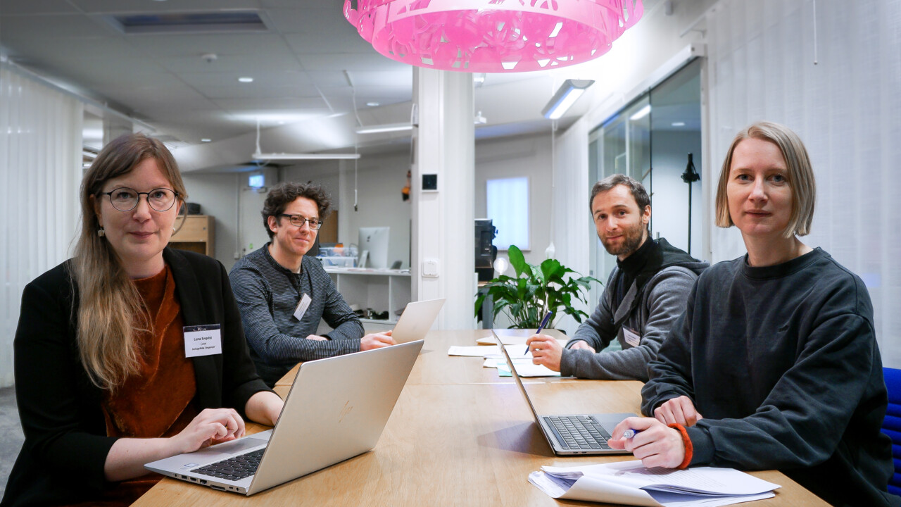 Bilden visar projektmedlemmarna för AutogrAIde, sittandes vid ett bord och som kollar in i kameran.