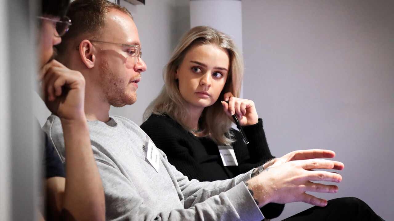 Bilden visar studenter som sitter och diskuterar.