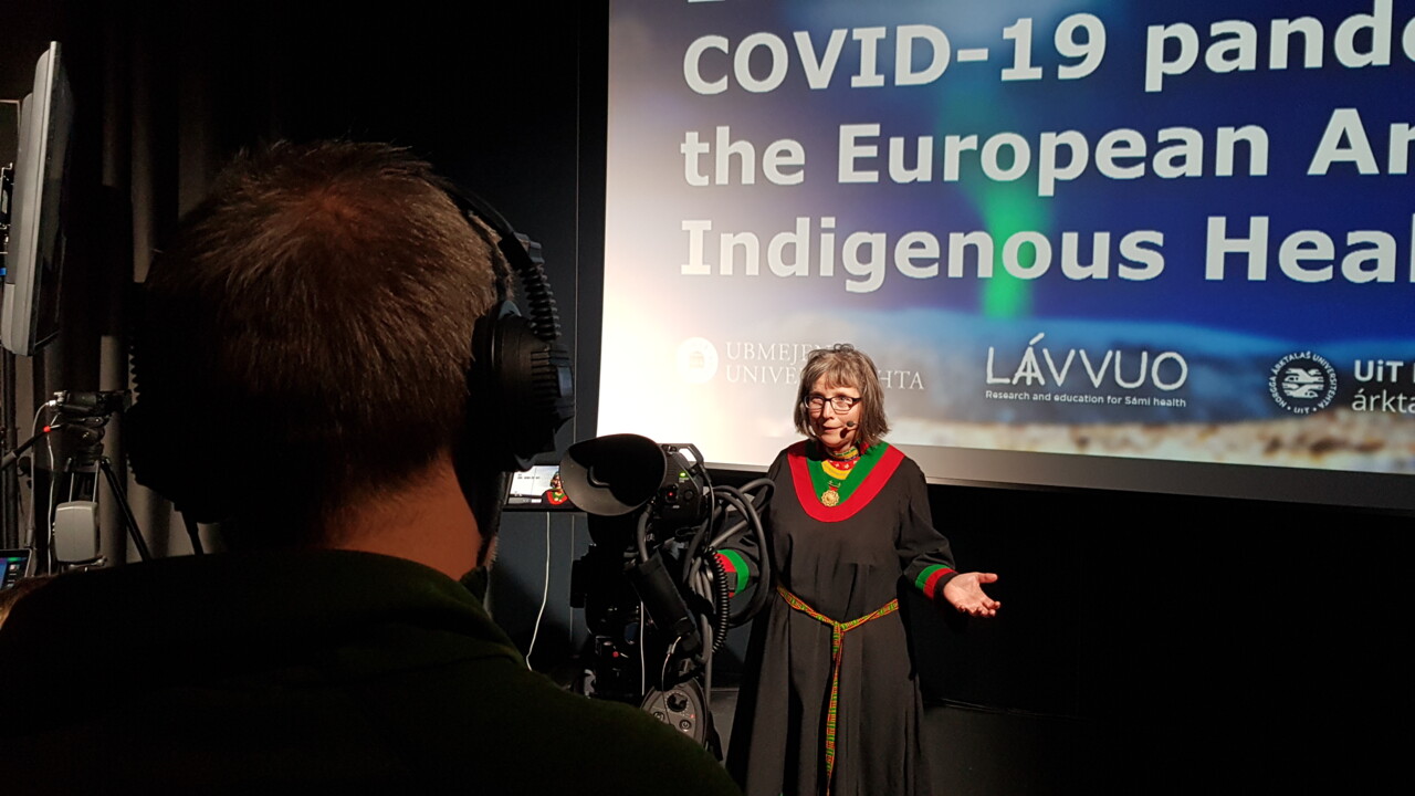 Kvinna i traditionell samisk dräkt står framför kamera.