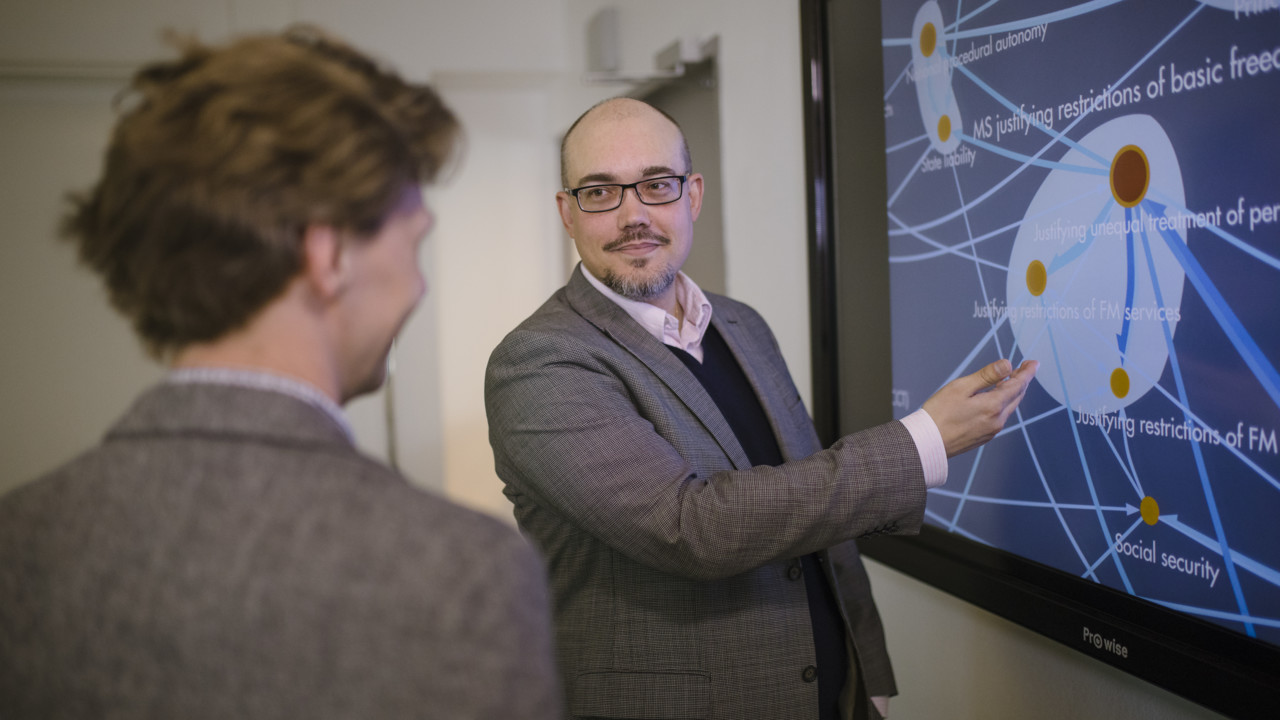 Mattias Derlén is showing an image to a colleague.