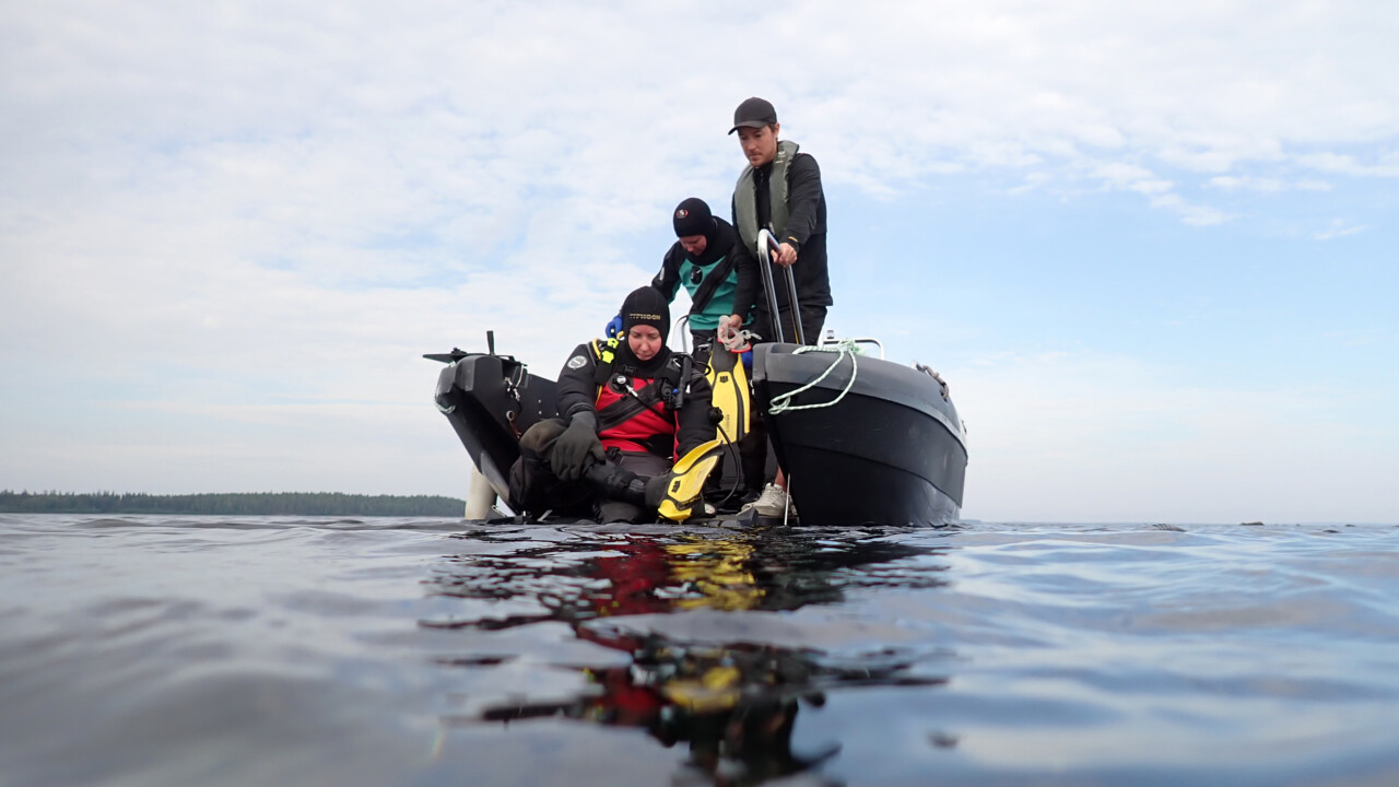 Dykare förbereder sig i båten.