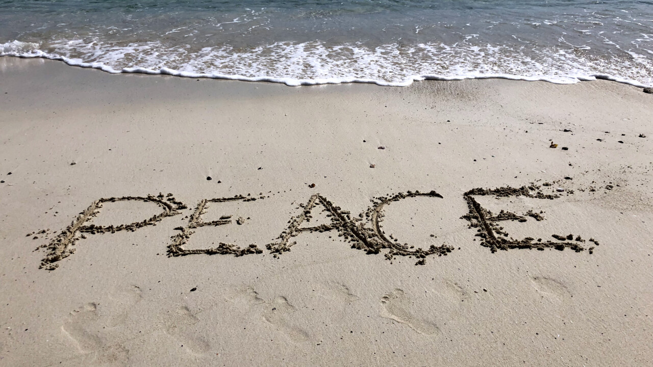 Bild på sandstrand där någon skrivit