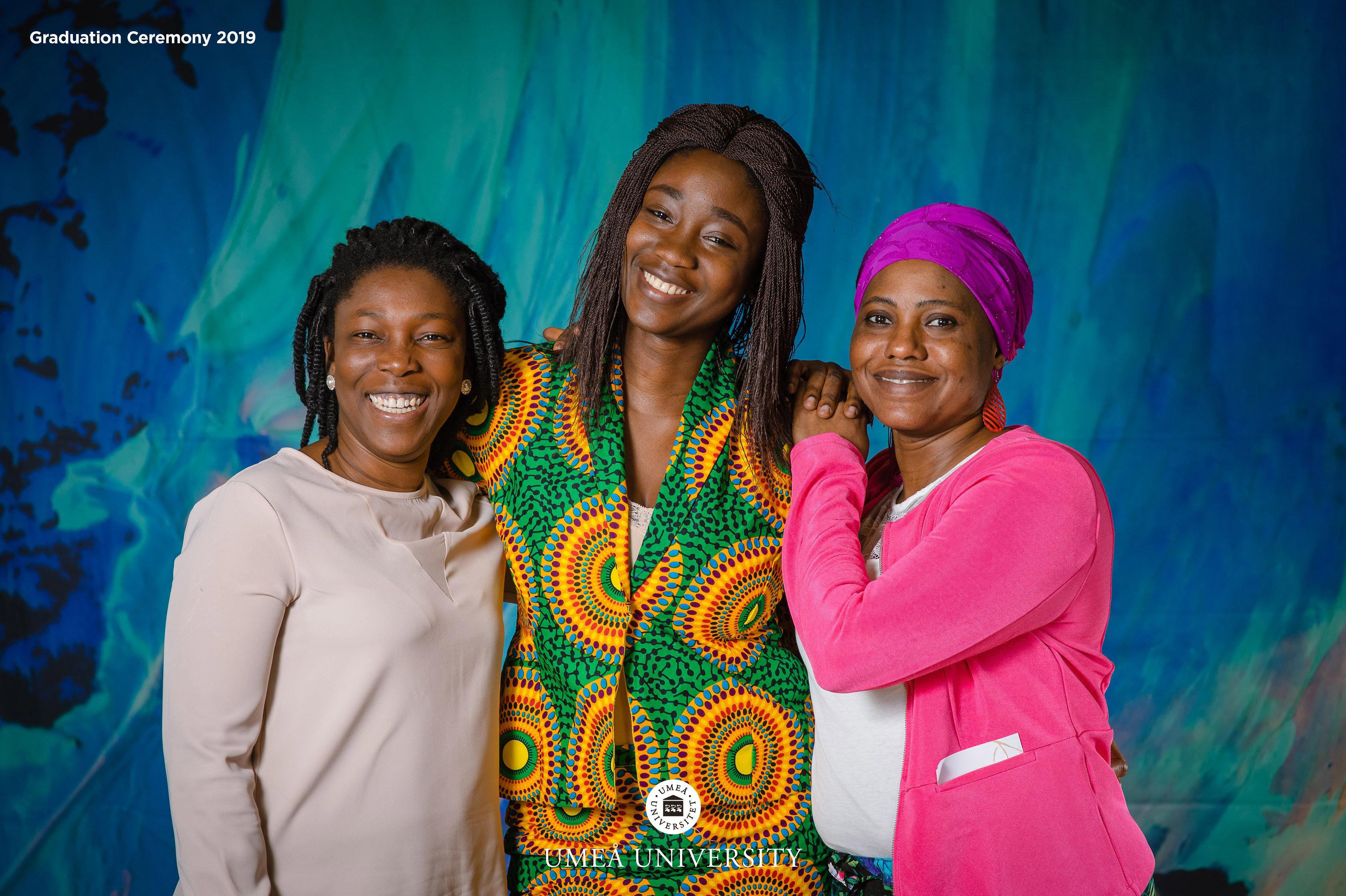 Gruppfoto med studenter framför backdrop med norrskensmotiv