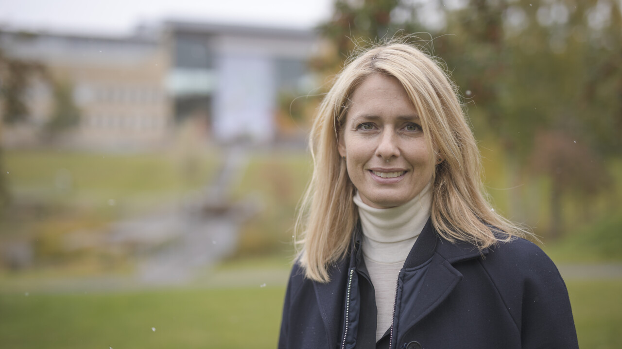 Helena Helmersson på Umeå universitets huvudcampus med Samhällsvetarhuset i bakgrunden. 