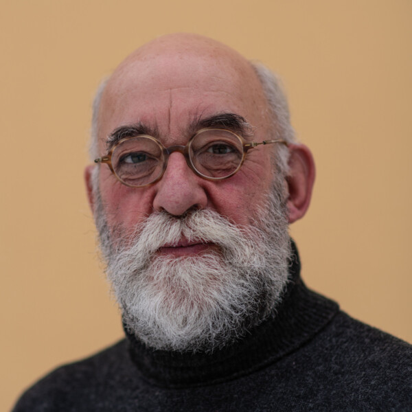 Man med glasögon och vitt skägg.