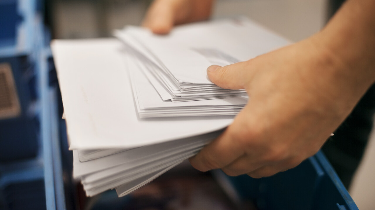 Händer som håller i en bunt med brev