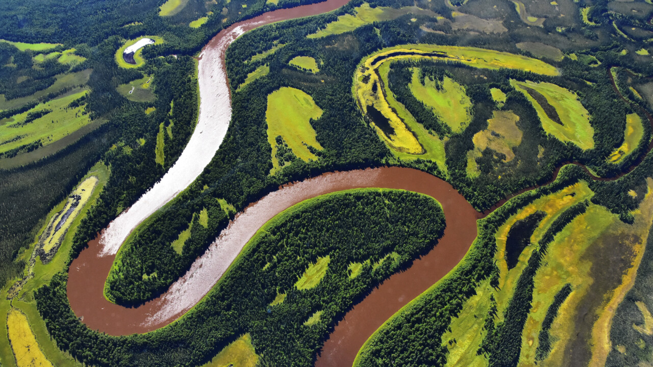 Flygbild som visar en flods meanderlopp i Alaska eller Kanada.