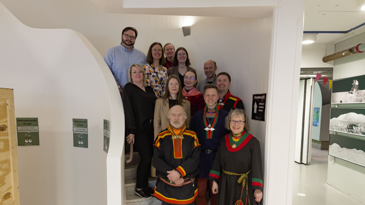 Samling av leende människor ståendes i en trappa