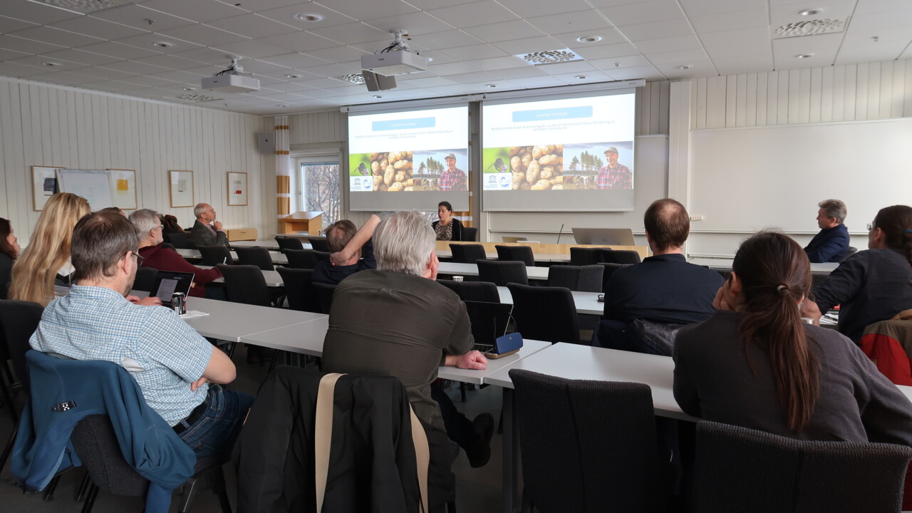 Elin Bergarp sits in front of a crowd, presenting on the biosphere area