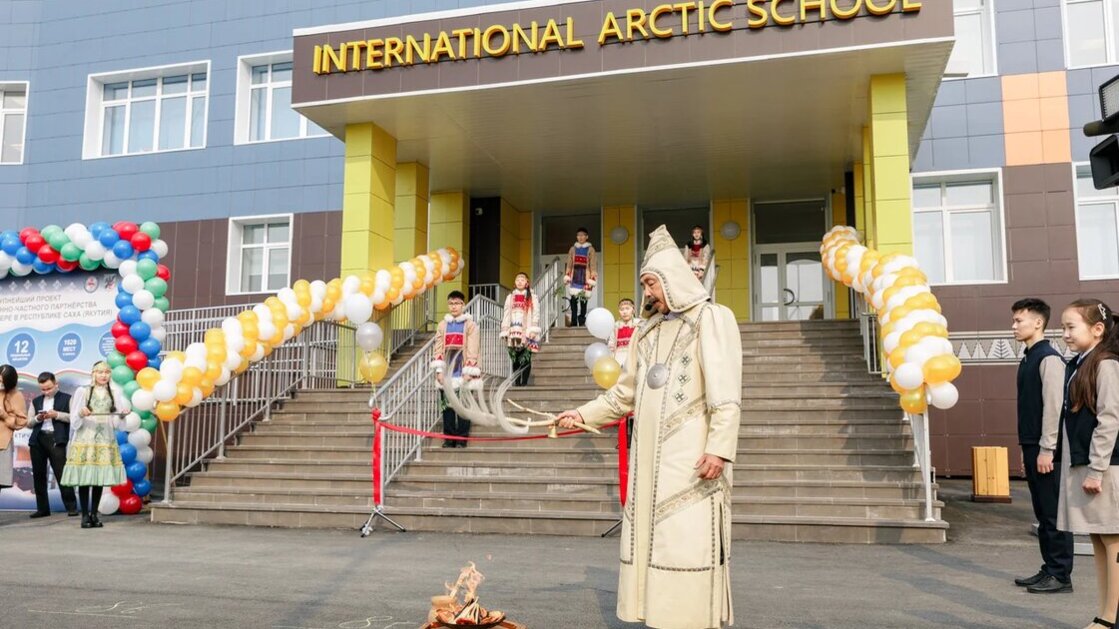 Inauguration ceremony. In the background on the stair stands students in traditional clothing