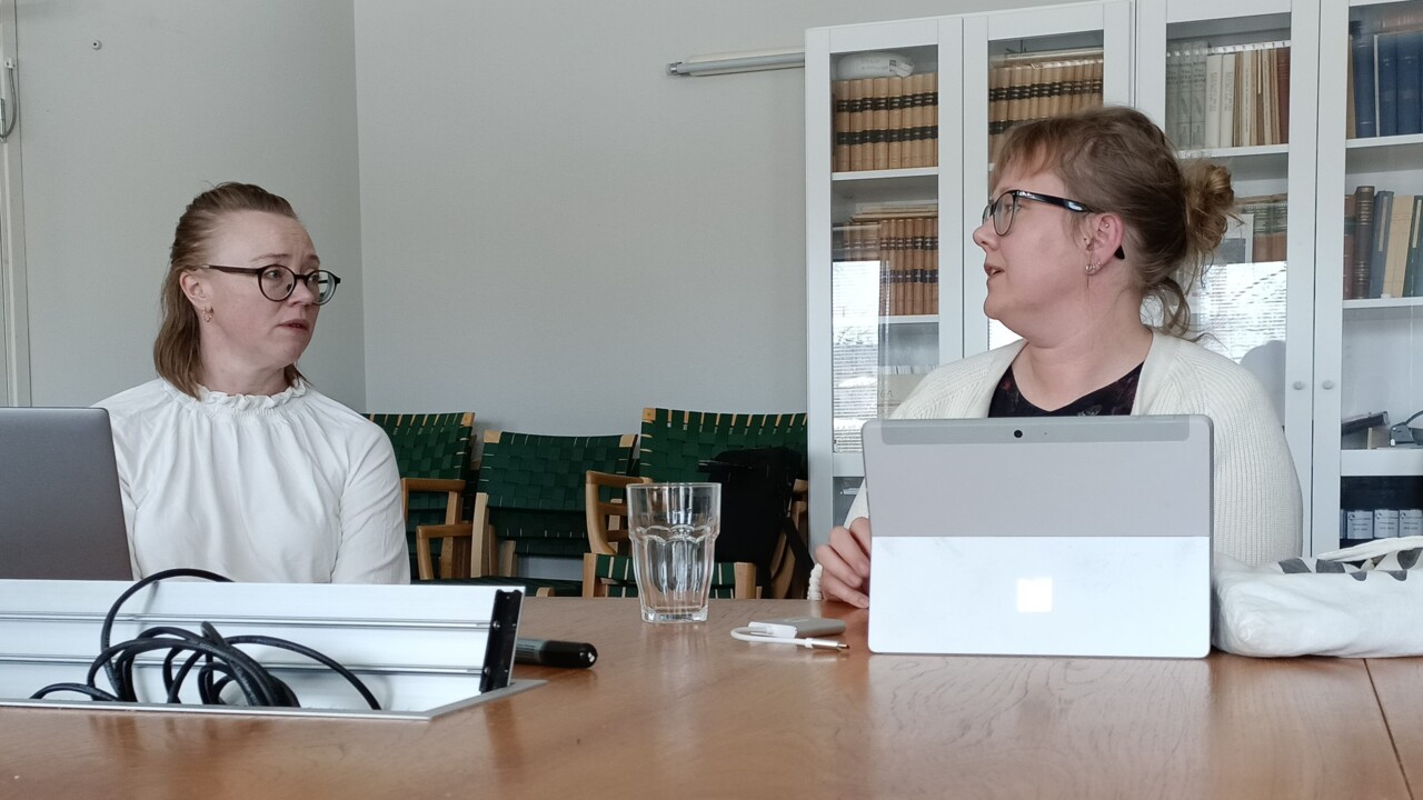 Linda Lundmark och Hanna Lempinen diskuterar vid ett bord