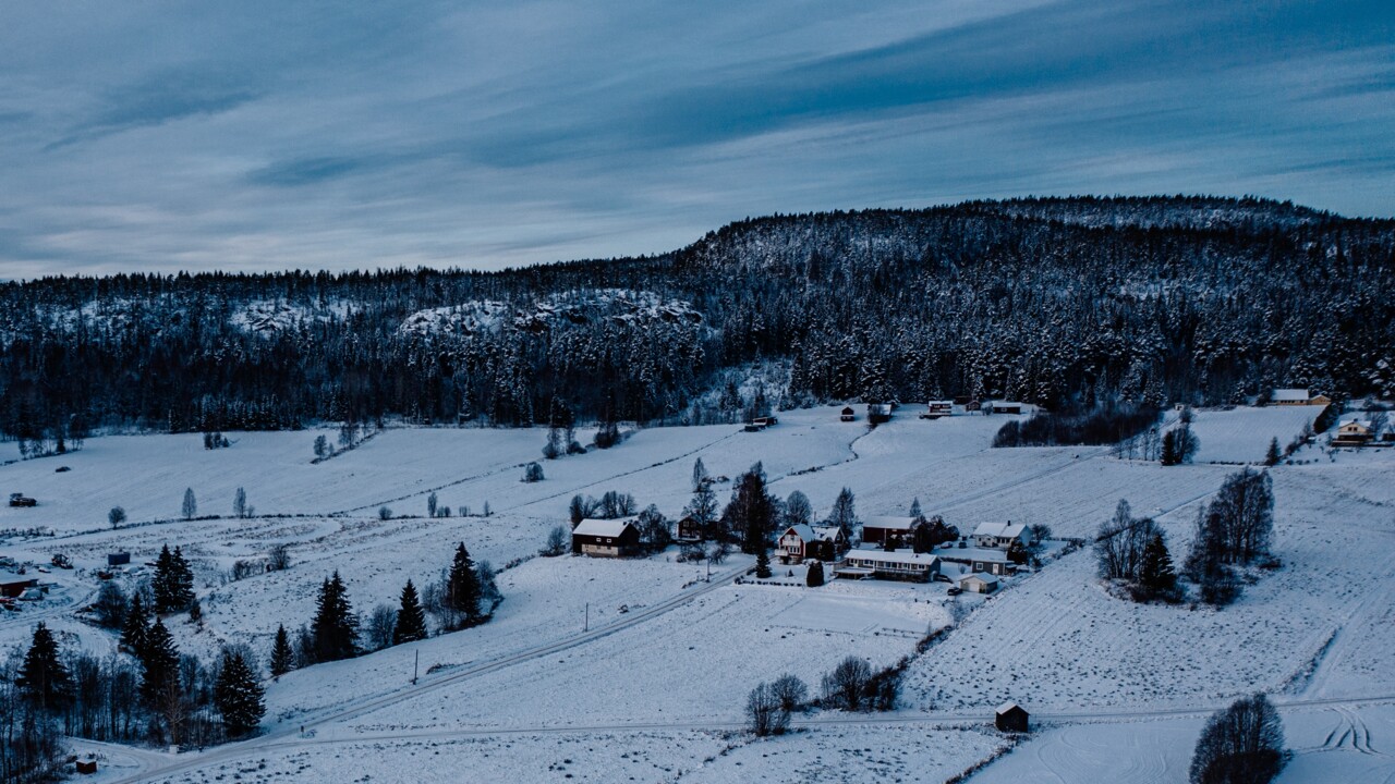 En snötäckt by i en mulen höstdag