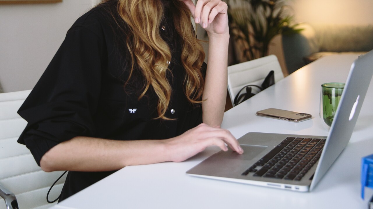 Kvinna sitter framför bärbar dator