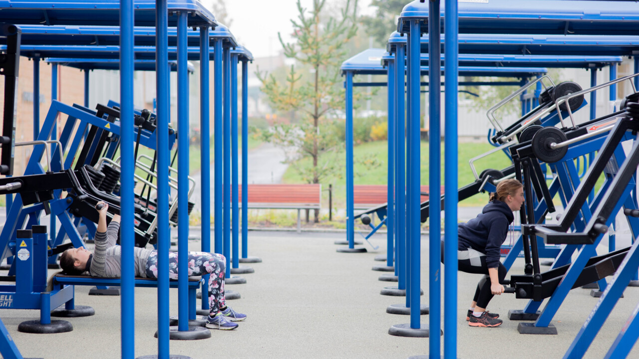 ung tjej som tränar på blå träningsmaskin utomhus
