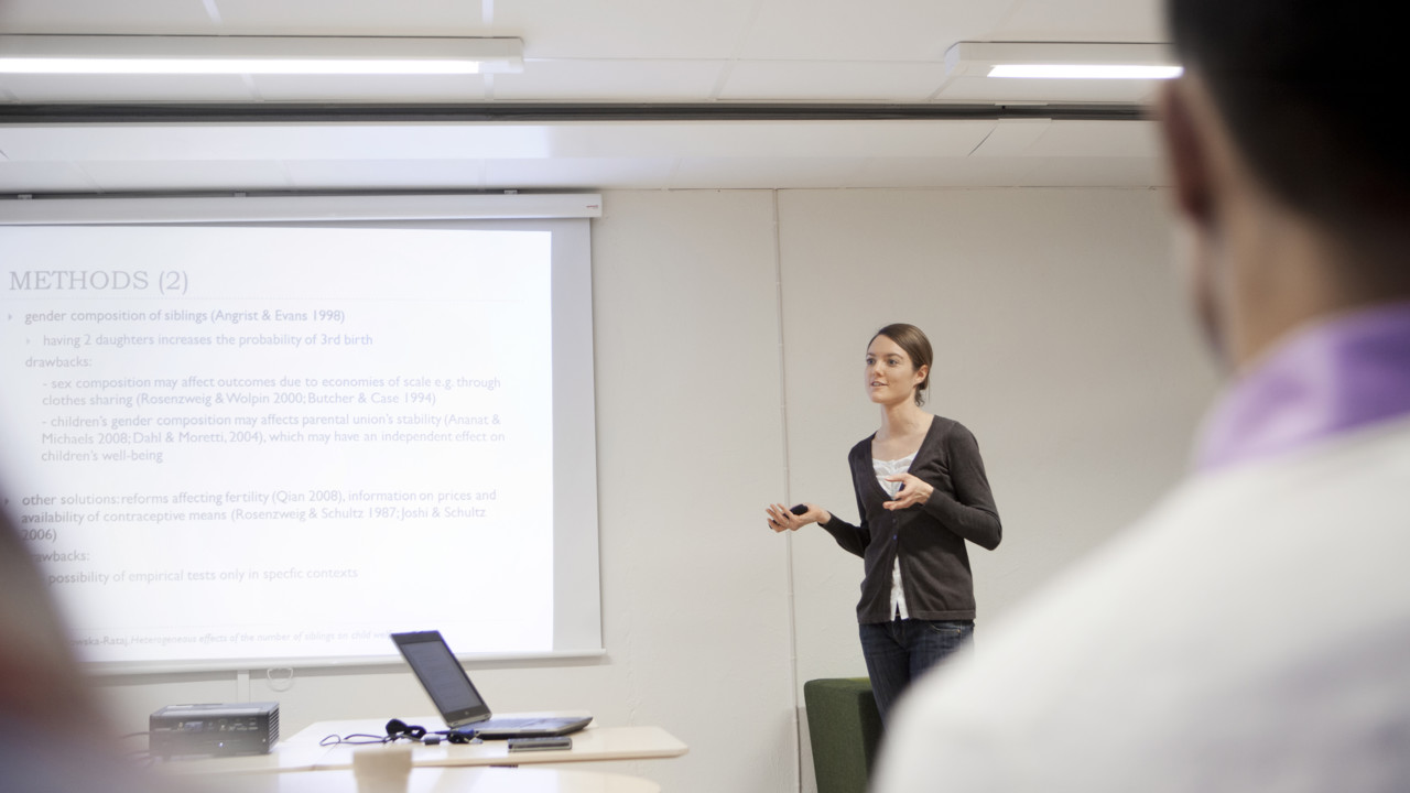 A young woman presenting a text in front of a audience