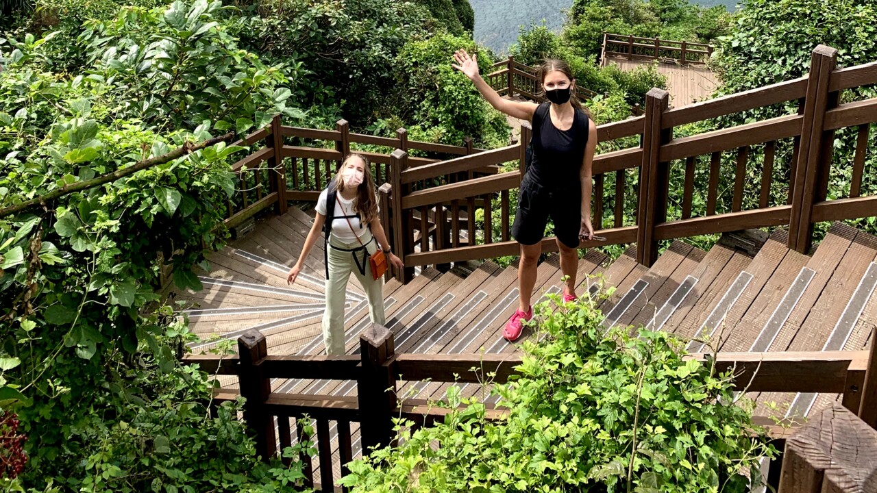 Foto med Signe och Anja ståendes på en trappa med utsikt över Seoul i bakgrunden.