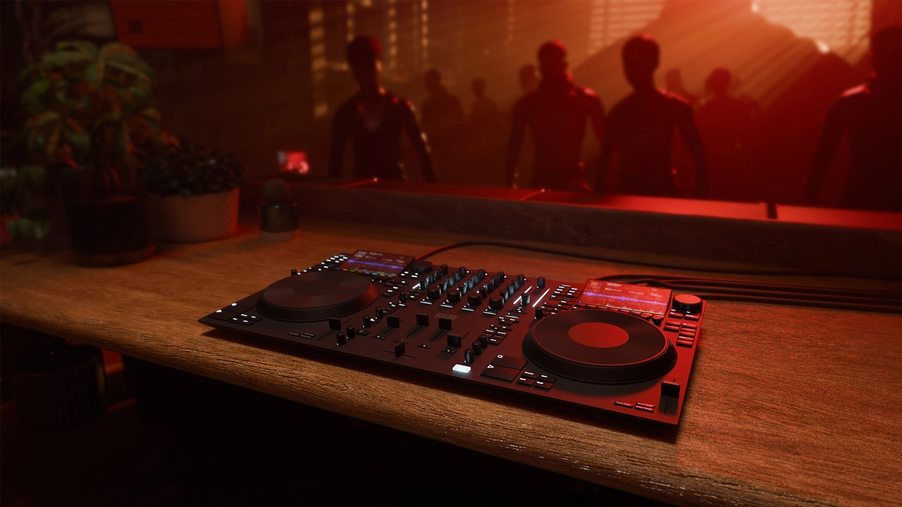 Photo of man in front of screen and dj control units