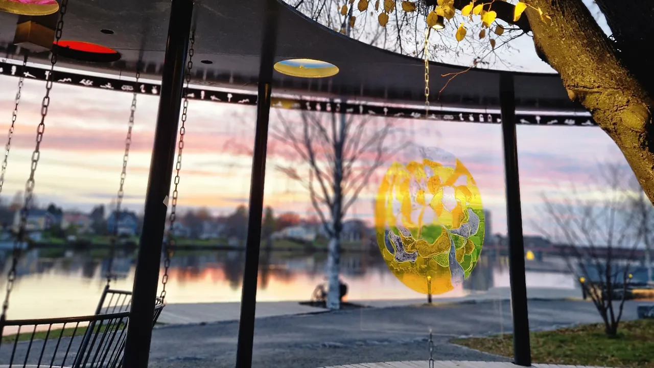 Färgad glasskiva vid höstlöv och älv