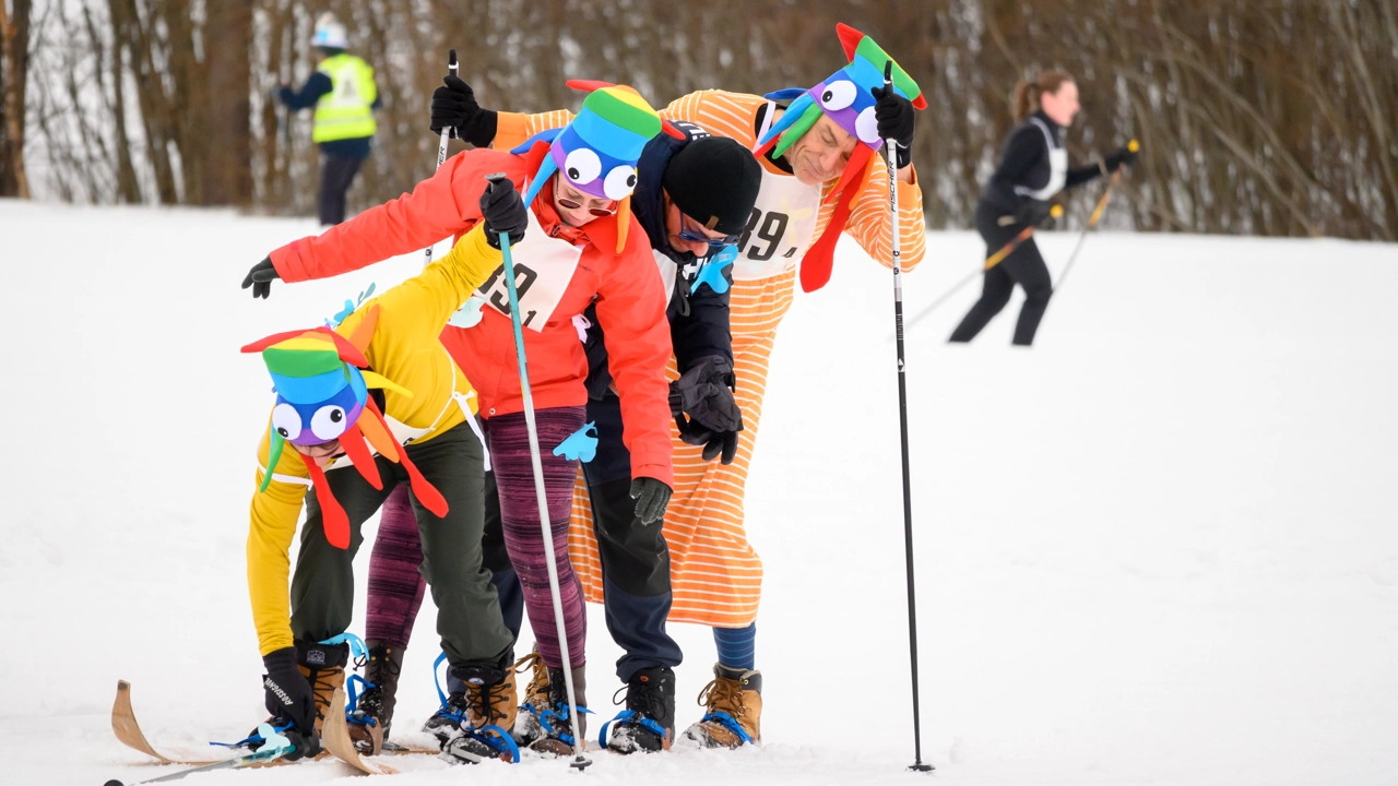 En grupp människor i färgglada kläder på skidor i snön
