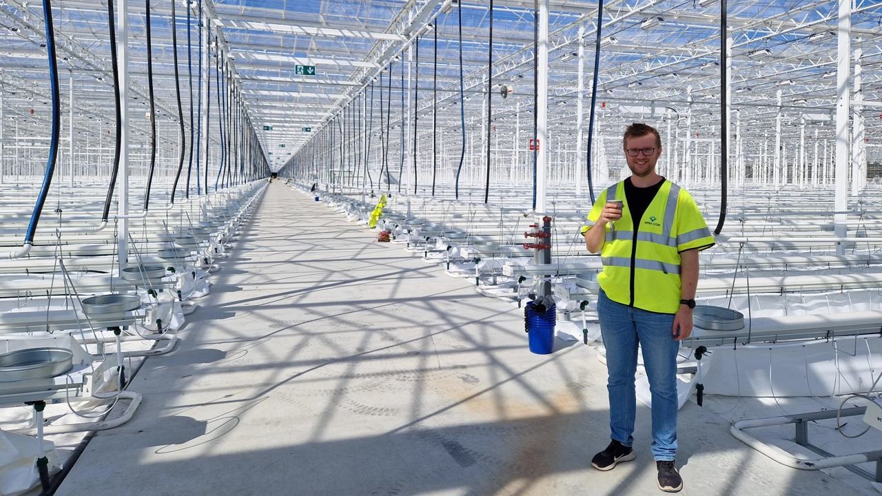 Bild på Axel Lindberg, stående i ett stort växthus.