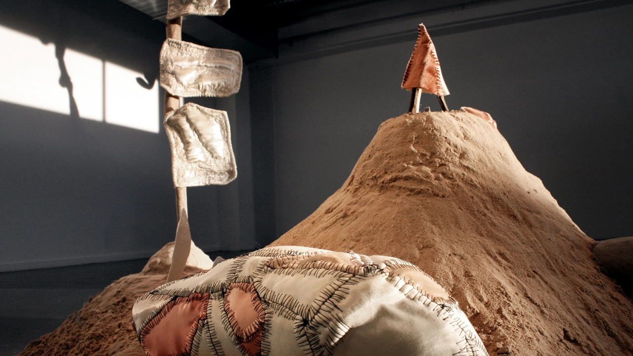 Sandhög med skulpturala textila objekt