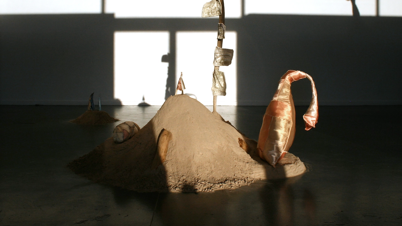 Sandhög med skulpturala textila objekt