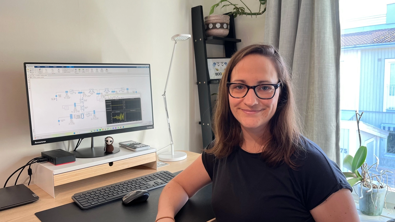 Bild på Anna NIlsson stående framför skrivbord med dator