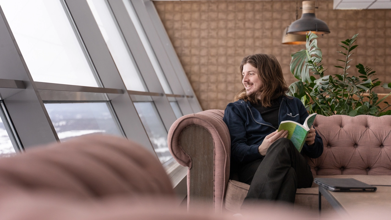 En student som har hittat ett mysigt ställe i en soffa att plugga på.