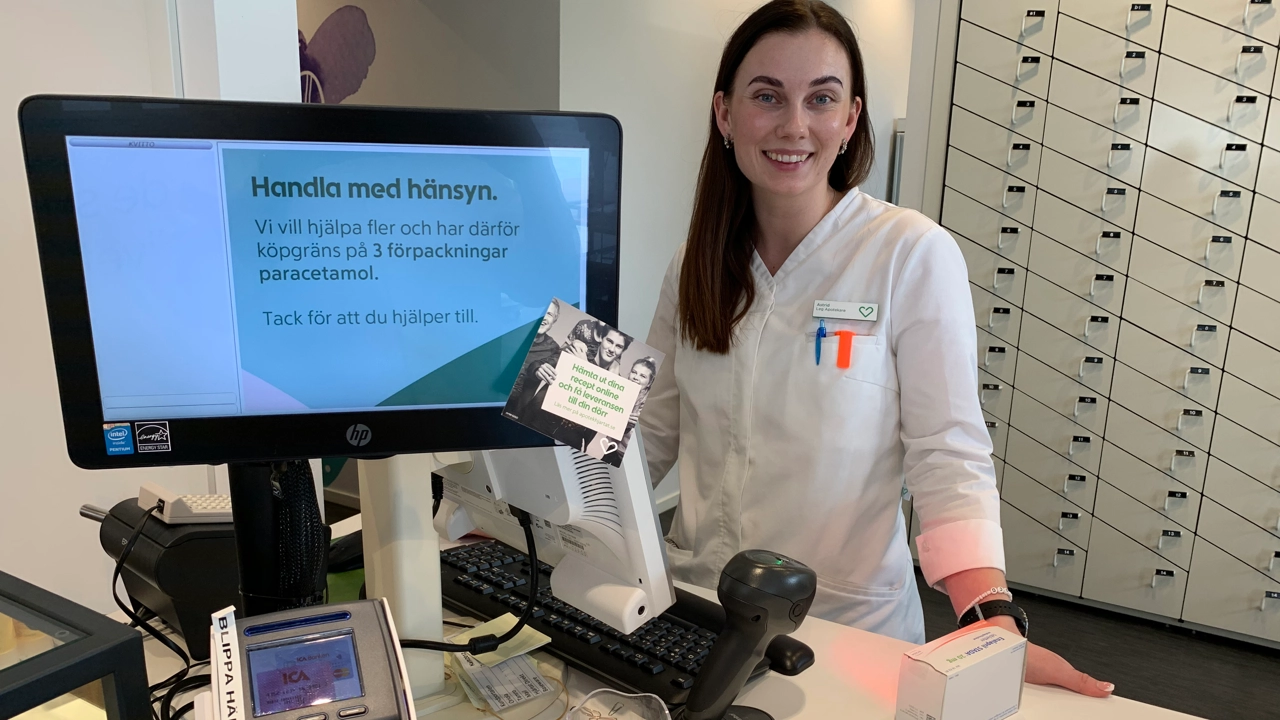 Bild på apotekaren Astrid Elander stående vid disken på ett apotek