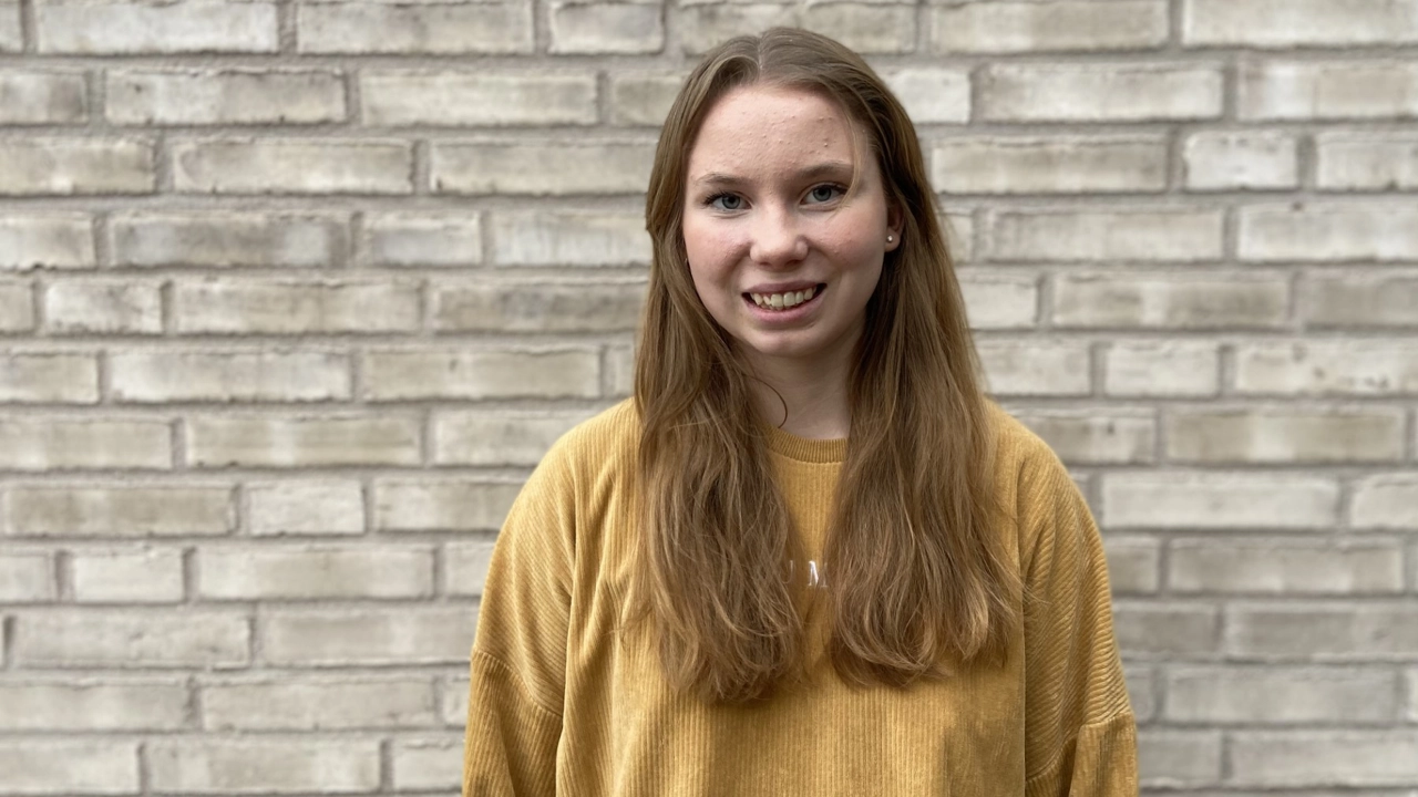 Porträttfoto på Astrid Norstedt, tegelvägg i bakgrunden