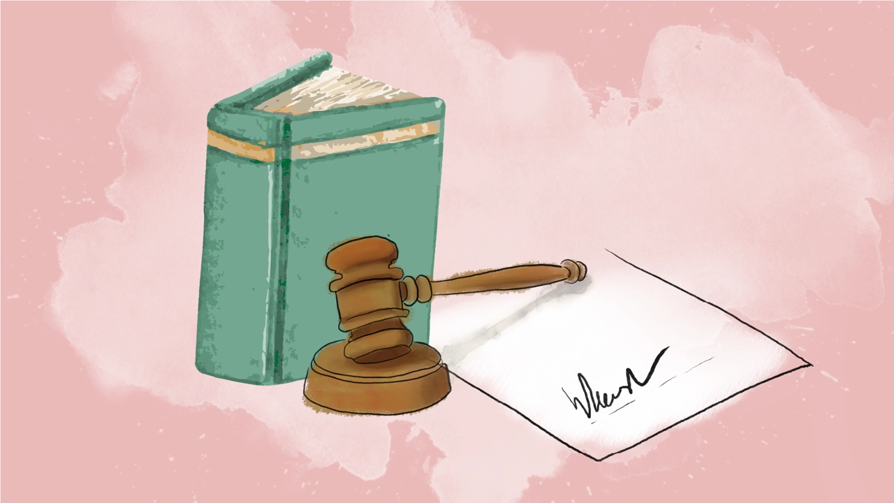 A law book, a wooden mallet and a signed agreement.