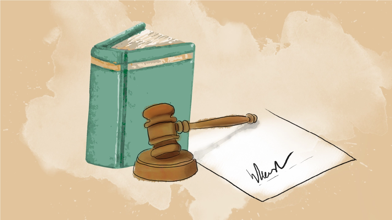 A law book, a wooden mallet and a signed agreement.