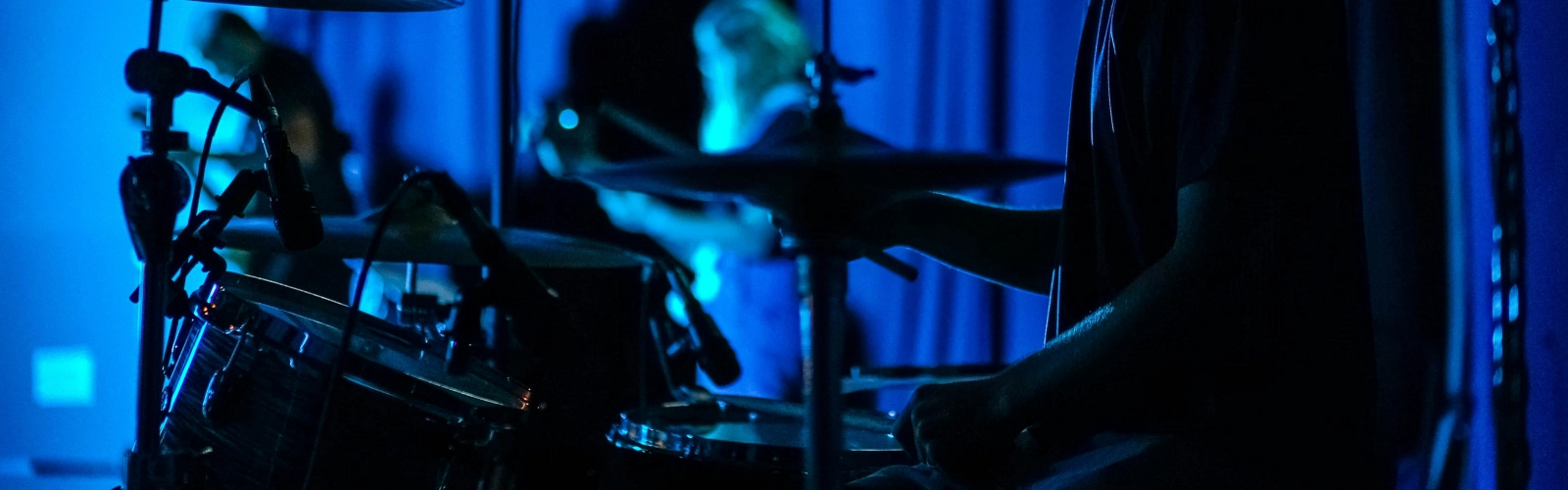 En man som spelar trummor i ett mörkt rum.